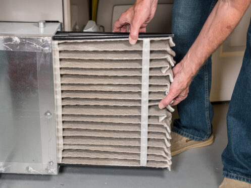 man changing air filter during winter in South Oregon